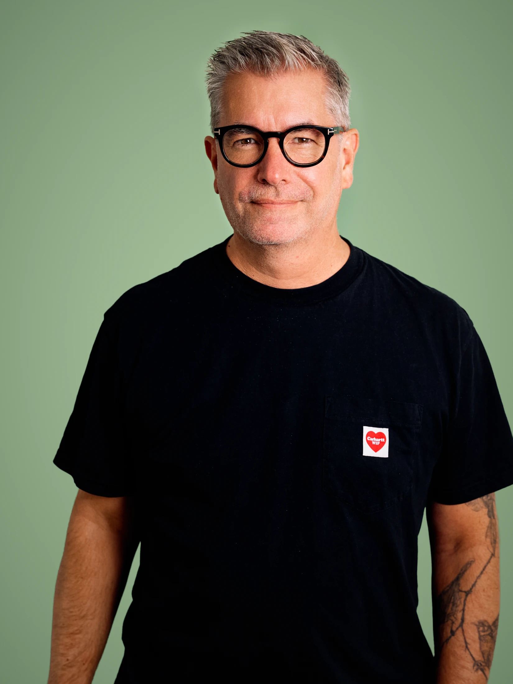Portrait of photographer Florian W. Mueller against a green background