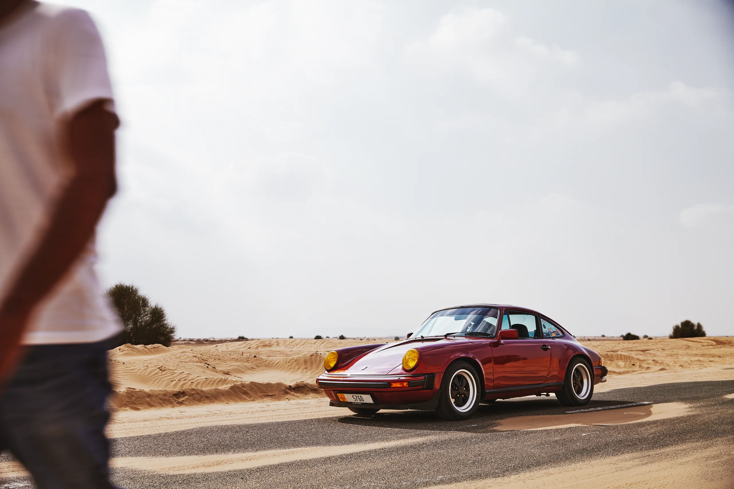 Wine-red 1982 Porsche 911 SC in urban and desert settings in Dubai.