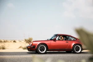 Wine-red 1982 Porsche 911 SC in urban and desert settings in Dubai.