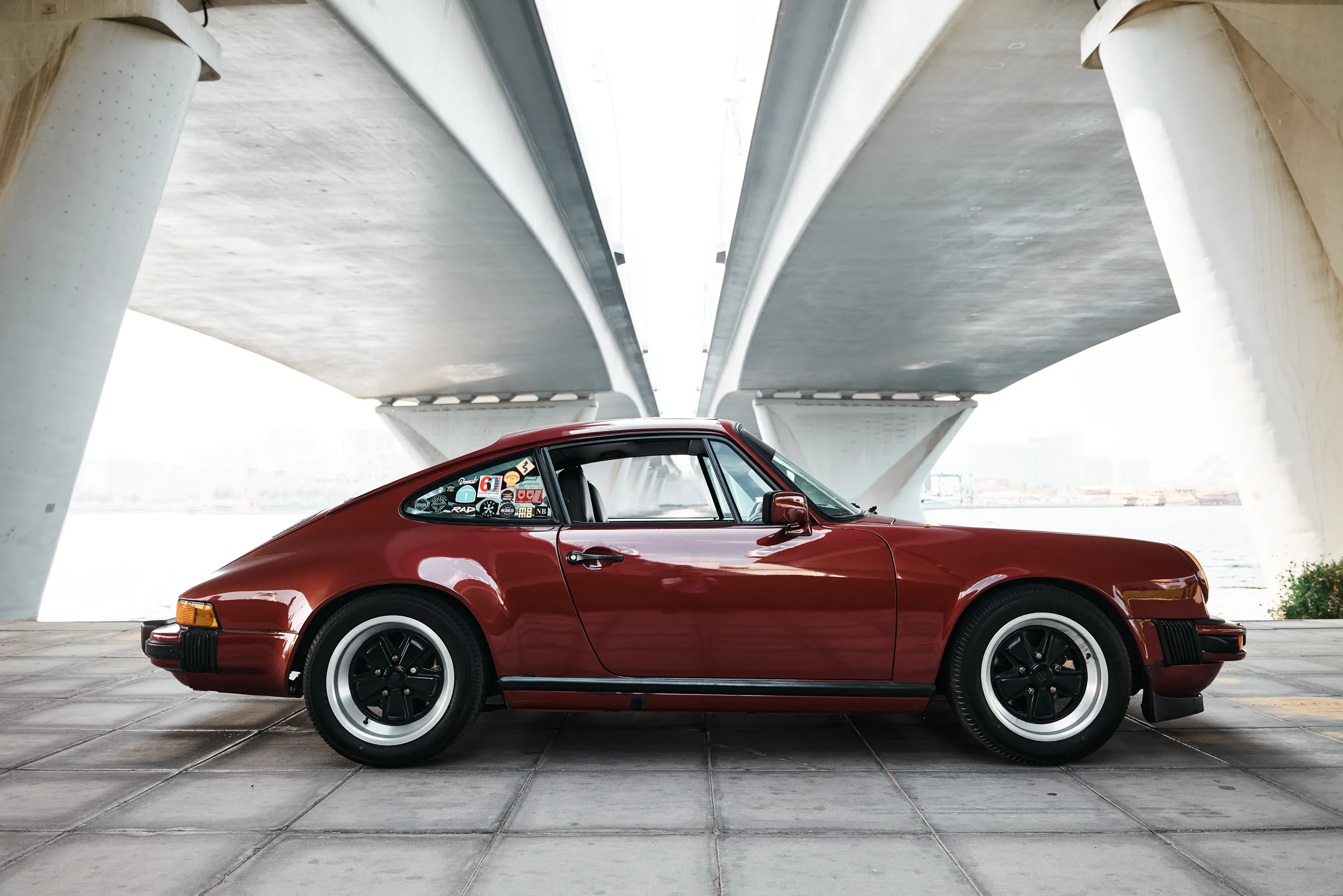 Wine-red 1982 Porsche 911 SC in urban and desert settings in Dubai.