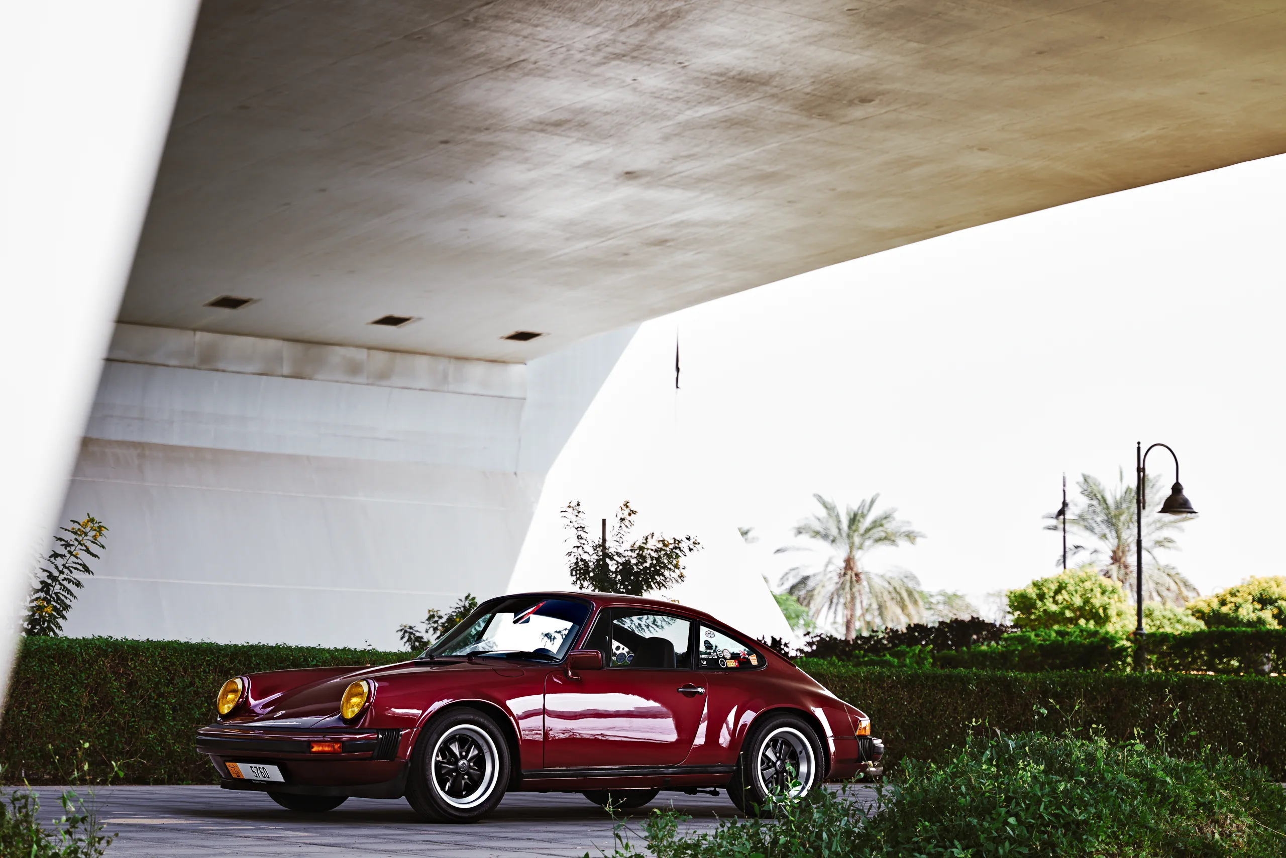 Wine-red 1982 Porsche 911 SC in urban and desert settings in Dubai.