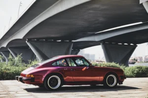 Wine-red 1982 Porsche 911 SC in urban and desert settings in Dubai.