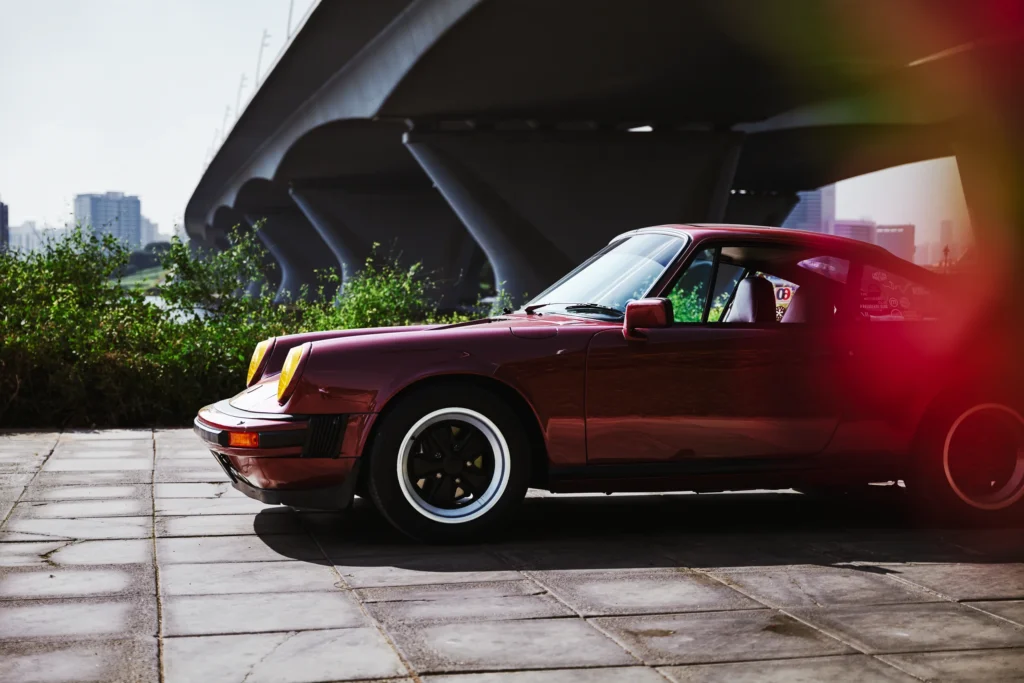 Wine-red 1982 Porsche 911 SC in urban and desert settings in Dubai.