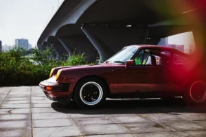 Wine-red 1982 Porsche 911 SC in urban and desert settings in Dubai.