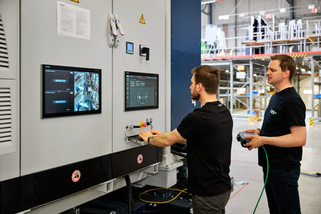 Two 4JET engineers operating the laser system control panel