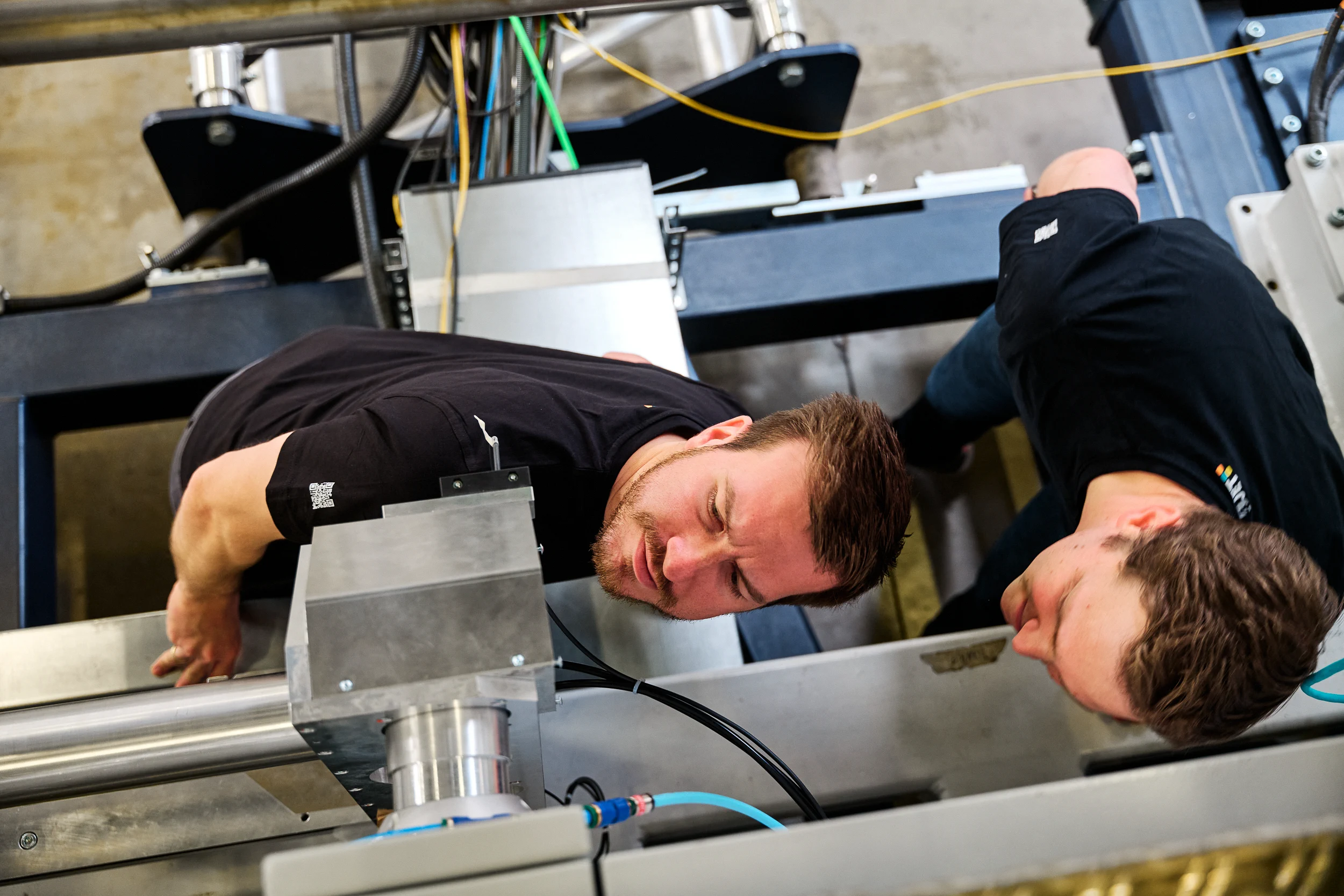 Two 4JET engineers inspecting the laser processing machine
