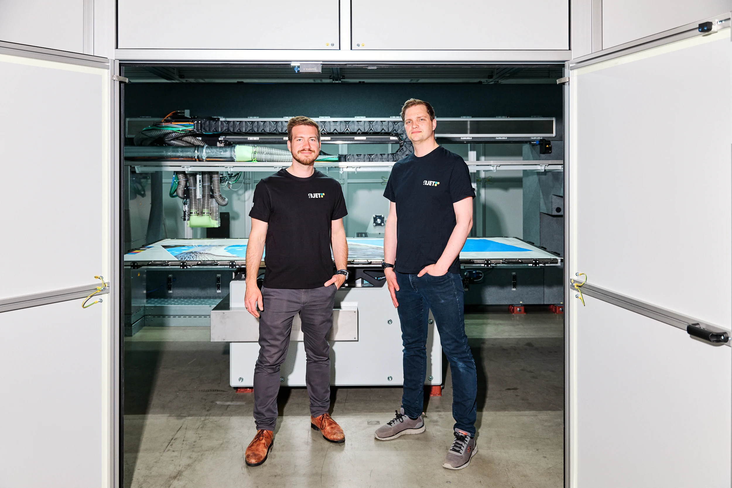 Portrait of two 4JET engineers in front of the laser system