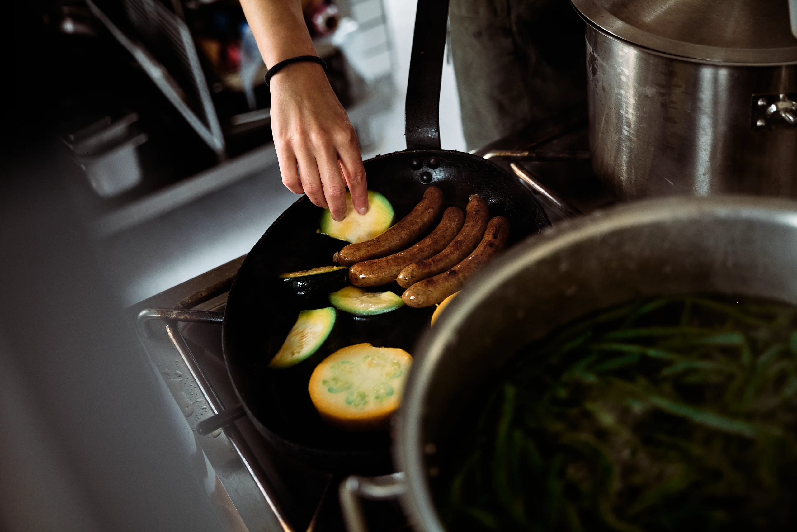 A chef cooking seasonal vegetables in a pan