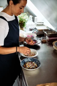 A chef plating a dish in the Birkemosegaard restaurant kitchen