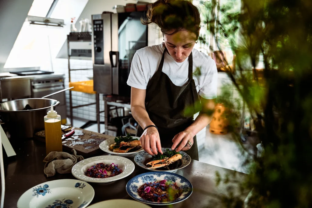 A chef serving dishes at an outdoor table
