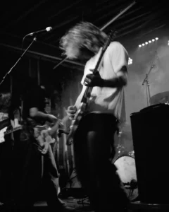Black-and-white photograph of a SØWT guitarist performing live at Bumann & Sohn in Cologne.