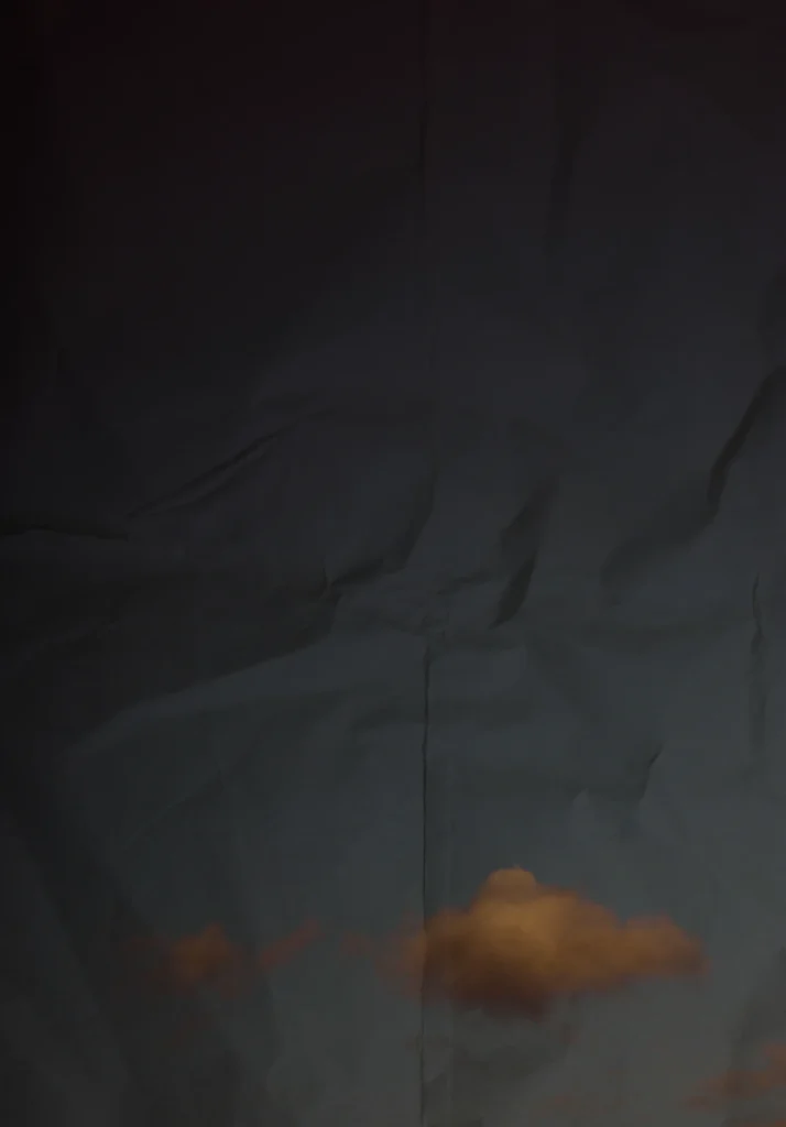 Double layer photography of sky with clouds and crumpled paper.